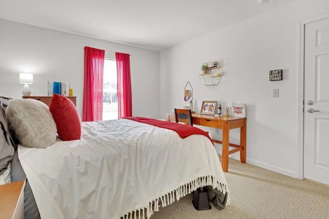 Bed with pillows desk chair and door bedroom at The Arch Troy in Troy Student Accommodation