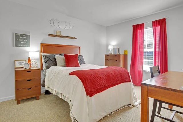 Bed with red blanket nightstand dresser and desk bedroom at The Arch Troy in Troy Student Accommodation