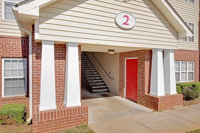 Red door metal stairs with number 2 exterior at The Arch Troy in Troy Student Accommodation