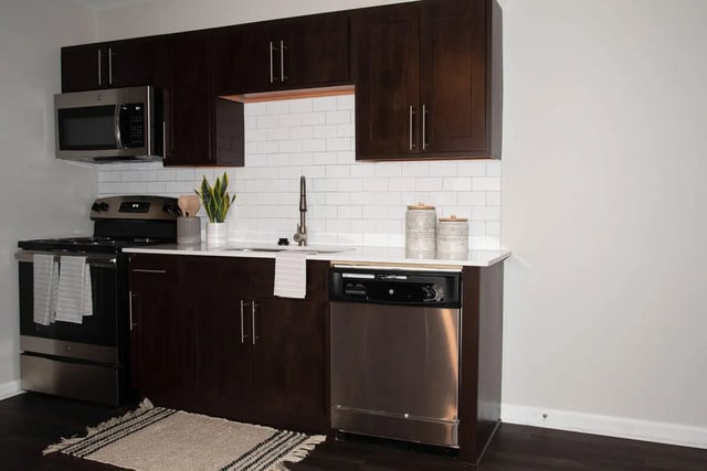 Dark cabinets stove microwave sink dishwasher kitchen at Grove at Auburn in Auburn Student Accommodation