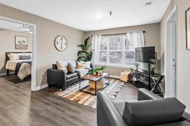 Leather couch coffee table rug and tv living room at Grove at Auburn in Auburn Student Accommodation