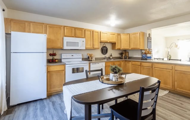 White refrigerator stove microwave table and chairs kitchen at Copper Beech Townhomes - Ames in Ames Student Accommodation