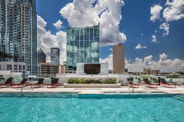 Pool lounge chairs outdoor TV cityscape exterior at The Henry in Tampa Student Accommodation
