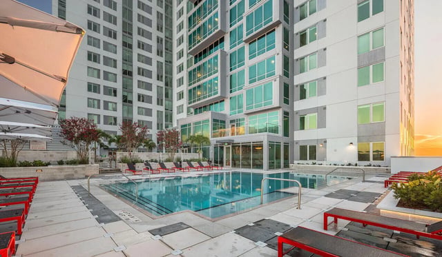 Pool with lounge chairs and umbrellas exterior at The Henry in Tampa Student Accommodation