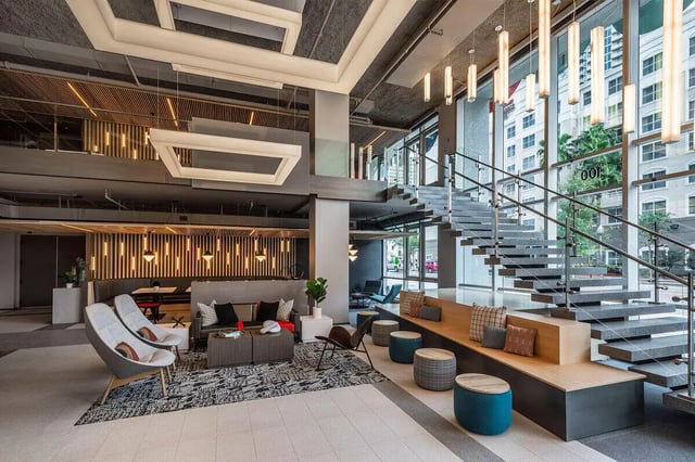 Modern lounge with seating and spiral staircase lounge area at The Henry in Tampa Student Accommodation