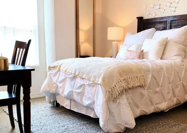 Bed desk lamp mirror floral wall art bedroom at The Verge at Las Cruces in Las Cruces Student Accommodation