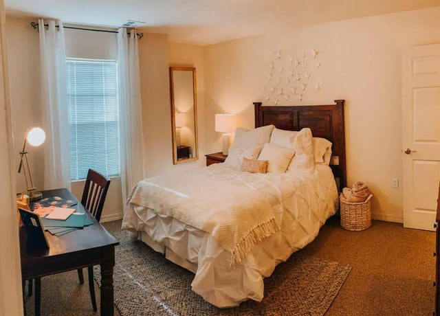 Bed desk lamp mirror white bedding basket bedroom at The Verge at Las Cruces in Las Cruces Student Accommodation