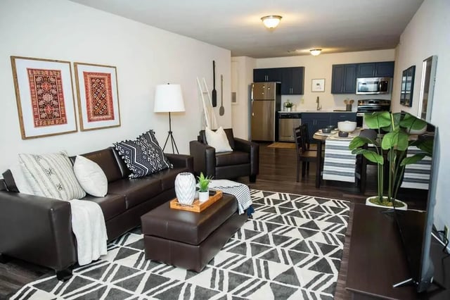 Brown sofa ottoman kitchen and dining area living room at Grove at Slippery Rock in Slippery Rock Student Accommodation