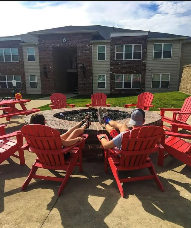 Two people relaxing at fire pit exterior at Grove at Slippery Rock in Slippery Rock Student Accommodation