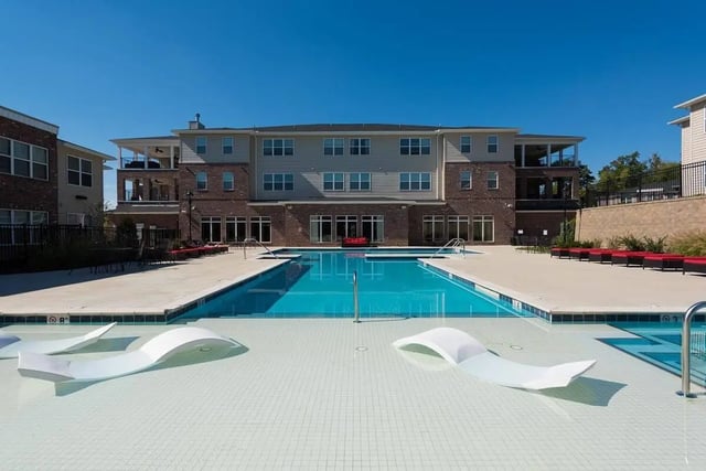 Modern student accommodation pool with lounge chairs exterior at Grove at Slippery Rock in Slippery Rock Student Accommodation