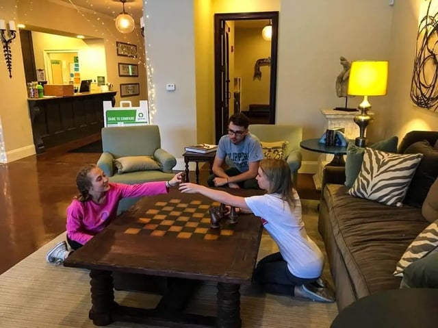 Students playing chess in common area living room at Grove at Slippery Rock in Slippery Rock Student Accommodation