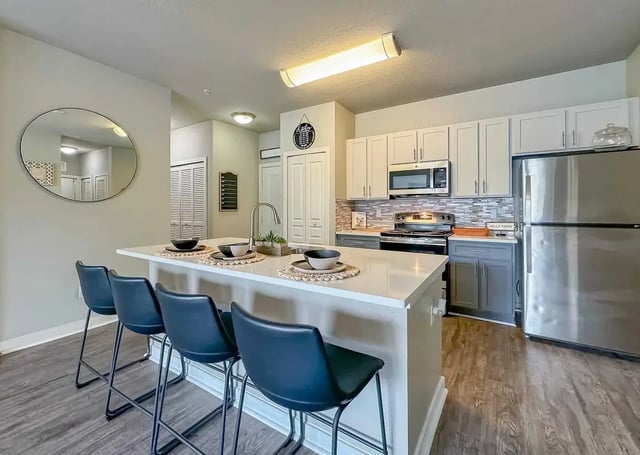 Four black stools island with sink kitchen appliances and cabinets kitchen at NXNW in Tallahassee Student Accommodation