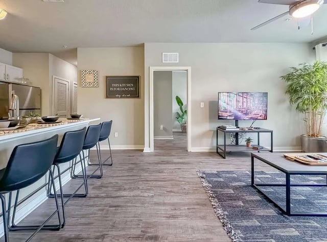 Kitchen island with bar stools and living room living room at NXNW in Tallahassee Student Accommodation