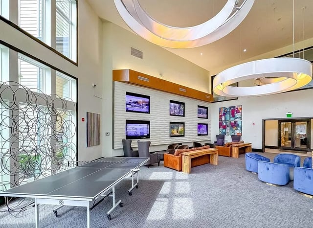 Ping pong table multiple screens art lounge area living room at NXNW in Tallahassee Student Accommodation