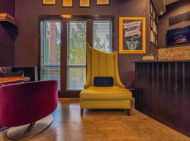 Yellow armchair dark bar red chair communal area at NXNW in Tallahassee Student Accommodation