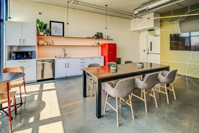 Kitchen counter sink red fridge dining table chairs common area at Chapter at Madison in Madison Student Accommodation
