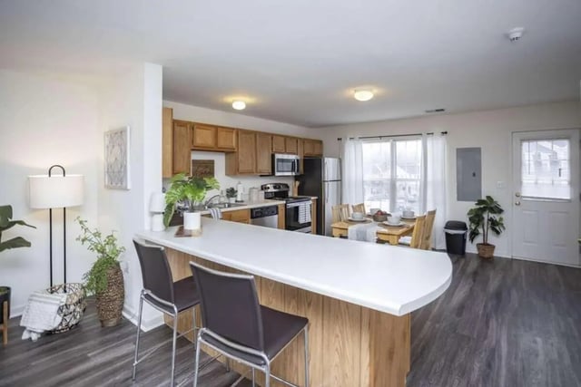 Kitchen island dining table and appliances kitchen at State College Collective in State College Student Accommodation