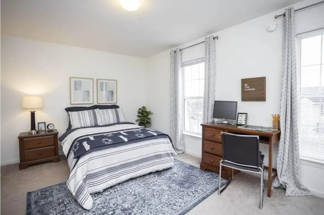 Bed desk lamp rug computer and framed art bedroom at Parkway Plaza in State College Student Accommodation