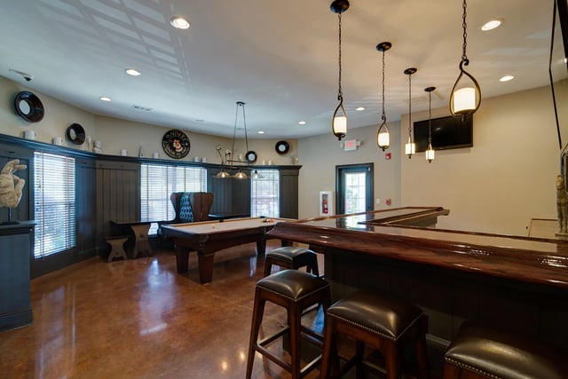Pool table bar stools and shiny bar area living room at Revelry Flats at Milledgeville in Milledgeville Student Accommodation
