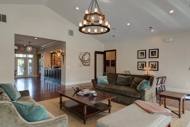 Living room with couches coffee table and chandelier living room at Revelry Flats at Milledgeville in Milledgeville Student Accommodation