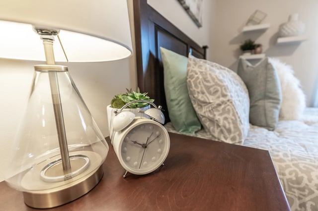 Alarm clock beside lamp and pillows bedroom at Revelry Flats at Milledgeville in Milledgeville Student Accommodation