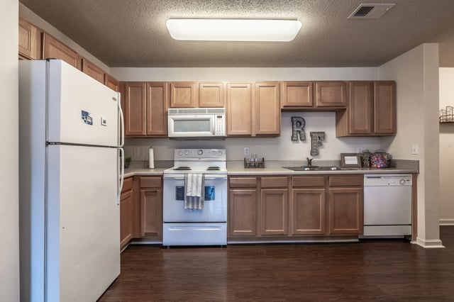 White refrigerator stove microwave and cabinets kitchen at Revelry Flats at Milledgeville in Milledgeville Student Accommodation