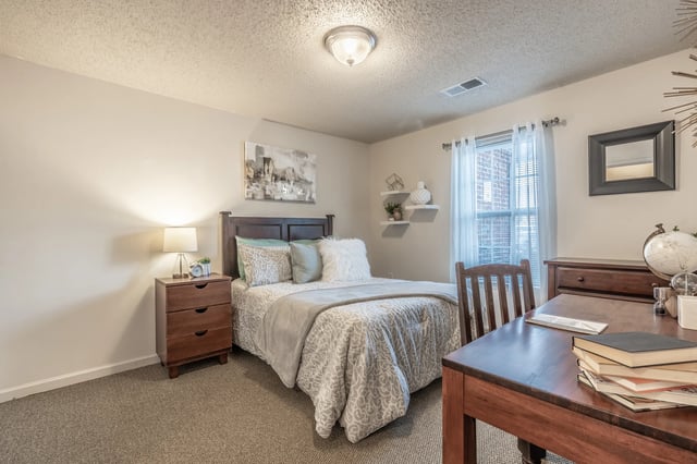 Bed nightstand desk chair and globe bedroom study area at Revelry Flats at Milledgeville in Milledgeville Student Accommodation