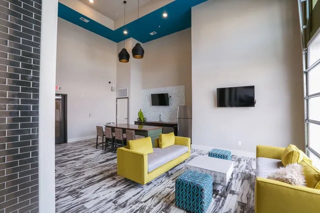 Yellow sofas and patterned ottomans in living area. at Douglas Heights in Chattanooga Student Accommodation