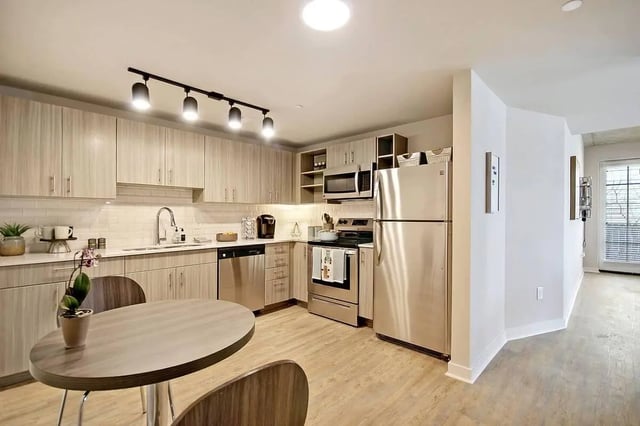 Modern kitchen with stainless steel appliances and dining table kitchen at Summit Place in Charleston Student Accommodation