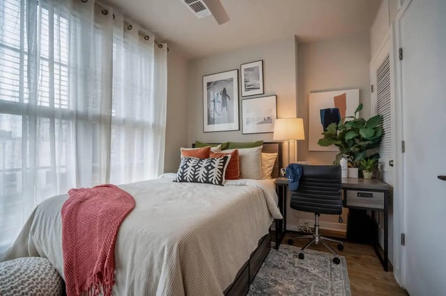 Bed with pink throw desk with chair bedroom at Summit Place in Charleston Student Accommodation