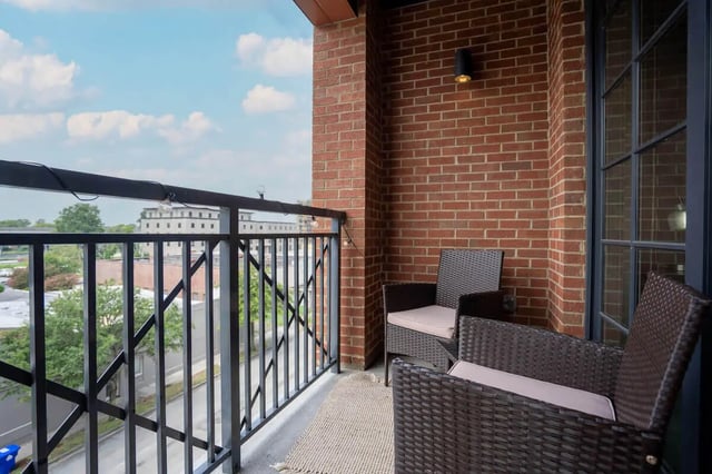 Two wicker chairs on brick balcony exterior at Summit Place in Charleston Student Accommodation