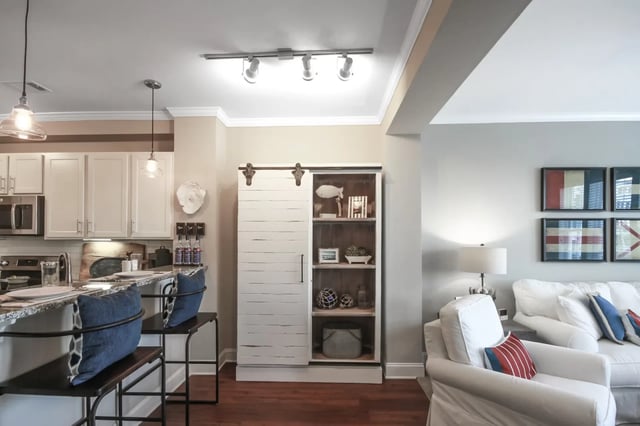 Kitchen island bar seating white cabinets barn door shelving living room at Sweetwater in Charleston Student Accommodation