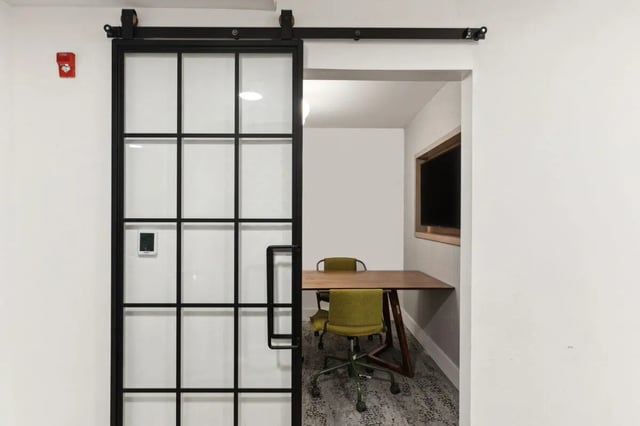Sliding door with glass panels and meeting table study area at Paloma at University City in Philadelphia Student Accommodation