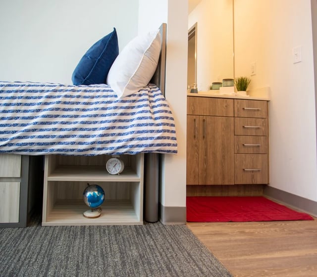 Bed with blue pillows globe and clock bathroom Image Type at Vantage in Philadelphia Student Accommodation