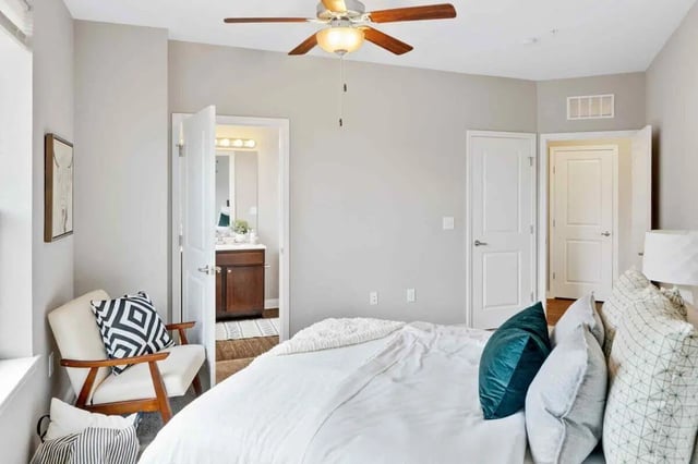 Bed ceiling fan chair pillows open bathroom bedroom at Midtown Stillwater in Stillwater Student Accommodation