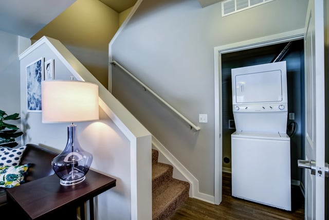 Stackable washer dryer beside carpeted stairs area at Edge 1120 in Toledo Student Accommodation