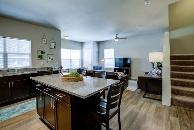 Island kitchen with living area and stairs at Edge 1120 in Toledo Student Accommodation