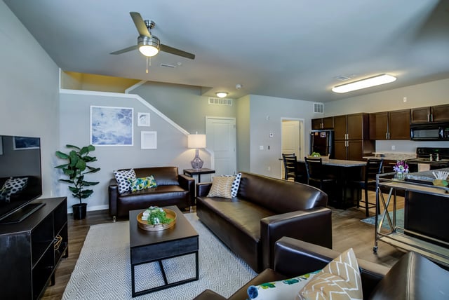 Leather sofas coffee table and kitchen area living room at Edge 1120 in Toledo Student Accommodation