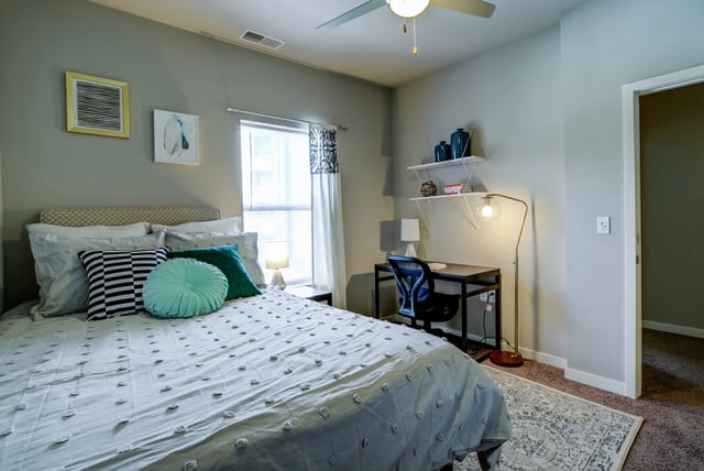 Bed desk chair artwork ceiling fan bedroom at Edge 1120 in Toledo Student Accommodation