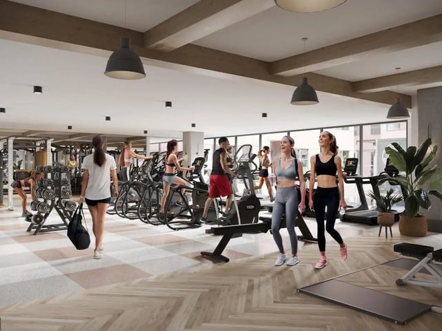 Gym equipment with people exercising and walking gym at Rambler Columbus in Columbus Student Accommodation