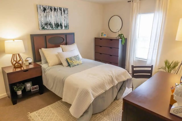 Bed with white bedding dresser mirror and desk Bedroom at The Grove at Cheney in Cheney Student Accommodation