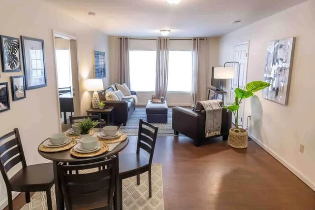 Dining table leather sofas ottoman and armchair Living room at The Grove at Cheney in Cheney Student Accommodation