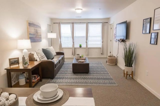 Brown couch ottoman rug and table Living room at The Grove at Cheney in Cheney Student Accommodation