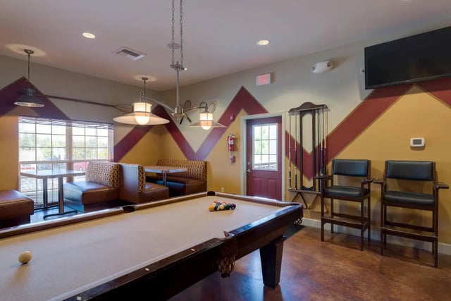 Pool table booths chairs and cue rack playing area at The Grove at Cheney in Cheney Student Accommodation