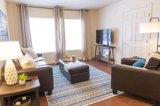 Leather sofas ottoman blue rug living room at The Grove at Cheney in Cheney Student Accommodation