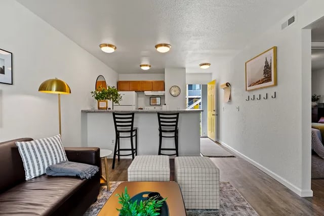 Couch kitchen bar stools and ottomans living room at Vivo | Toledo in Toledo Student Accommodation