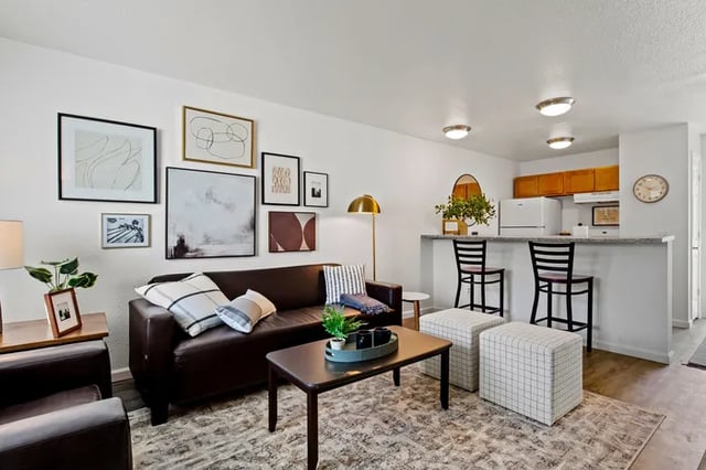 Brown couch coffee table art kitchen island bar stools living room at Vivo | Toledo in Toledo Student Accommodation