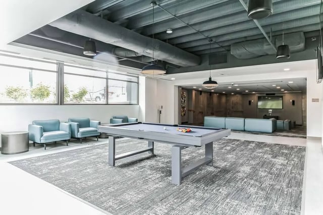 Pool table armchairs couches and TV lounge at Current Midtown in Williamsburg Student Accommodation