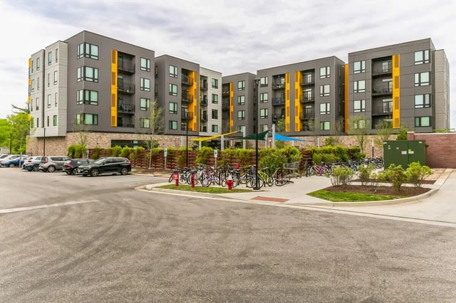 Apartment building with parked cars and bicycles exterior at Current Midtown in Williamsburg Student Accommodation