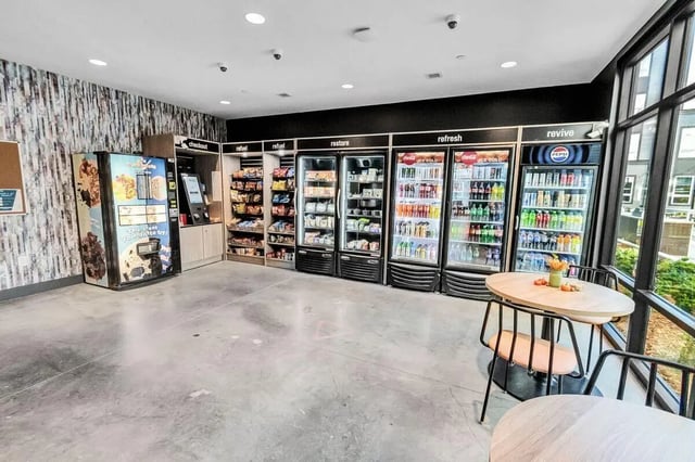 Vending machines and refrigerators with snacks and drinks amenity area at Junction 49 in Charlotte Student Accommodation